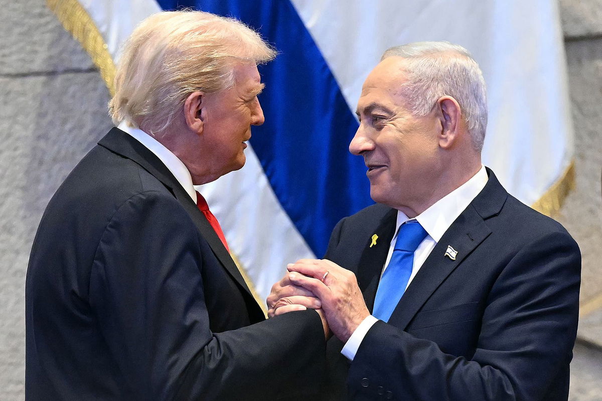 Donald Trump holds hands and speaks with Israeli Prime Minister Benjamin Netanyahu at the Israeli parliament