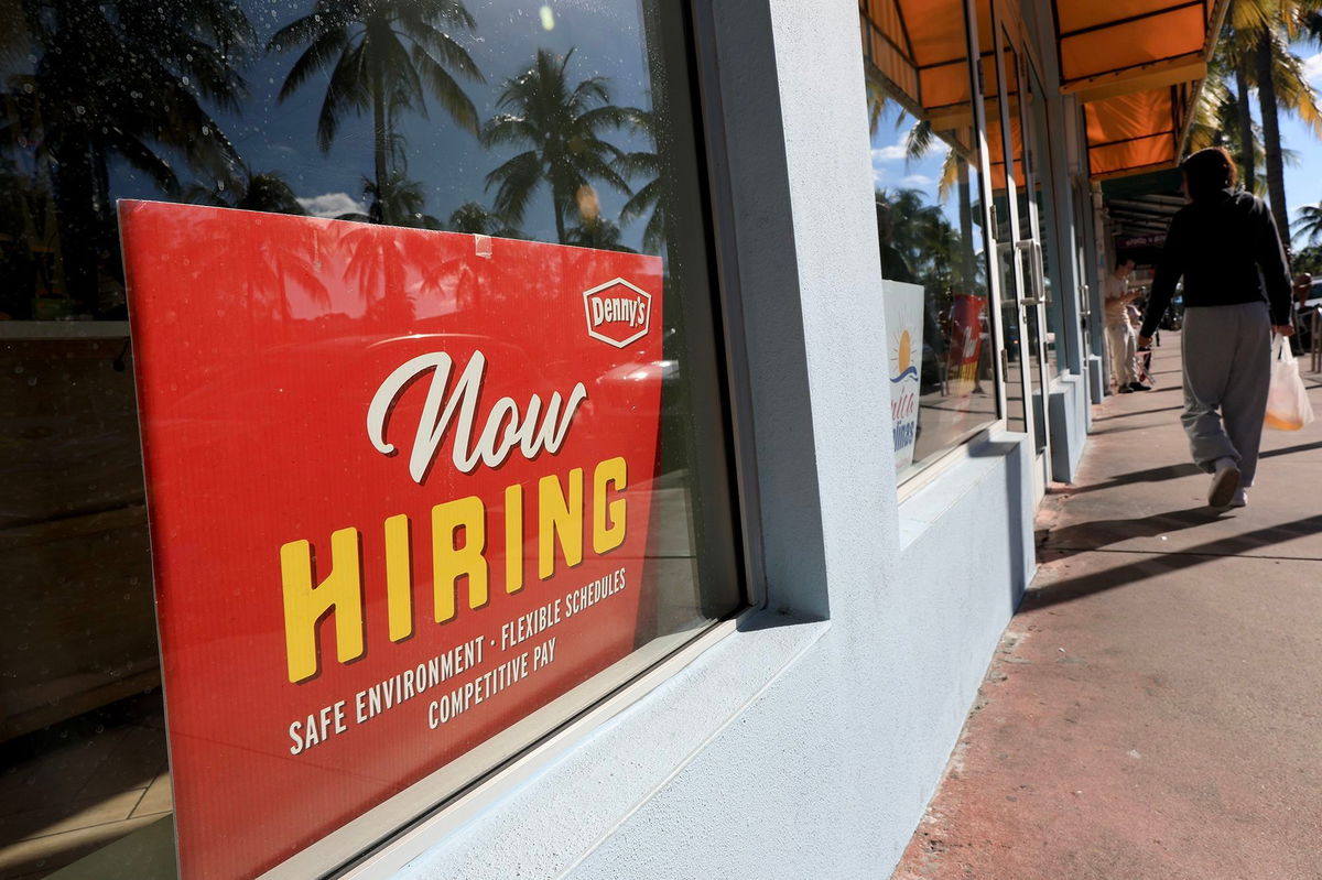 A 'Now Hiring' sign sits in the window of a Denny's restaurant on November 19 in Miami.