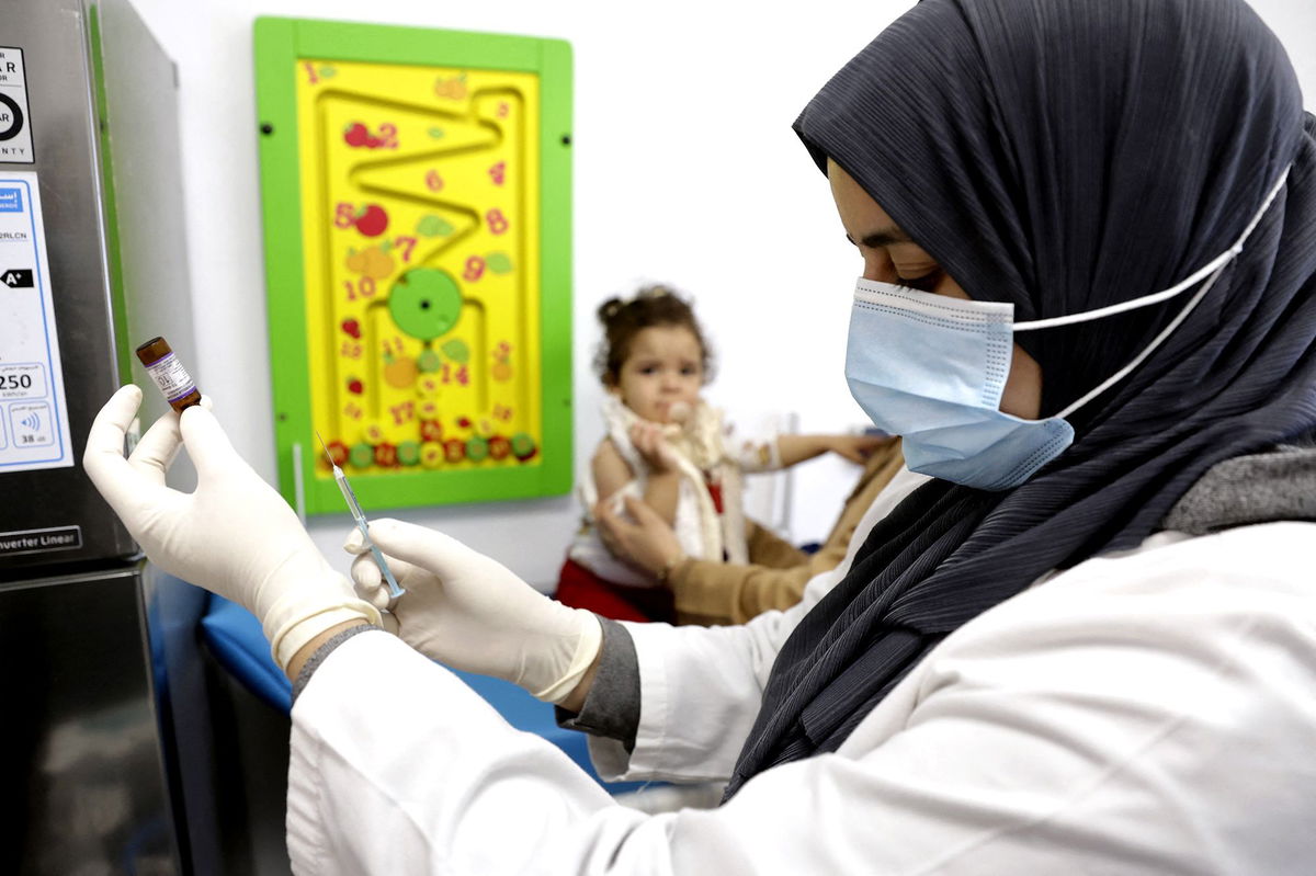 A child waits as a nurse prepares a dose of measles vaccine at a hospital in the Moroccan coastal city of Temara in February 2025. Measles and meningitis infections killed at least 100