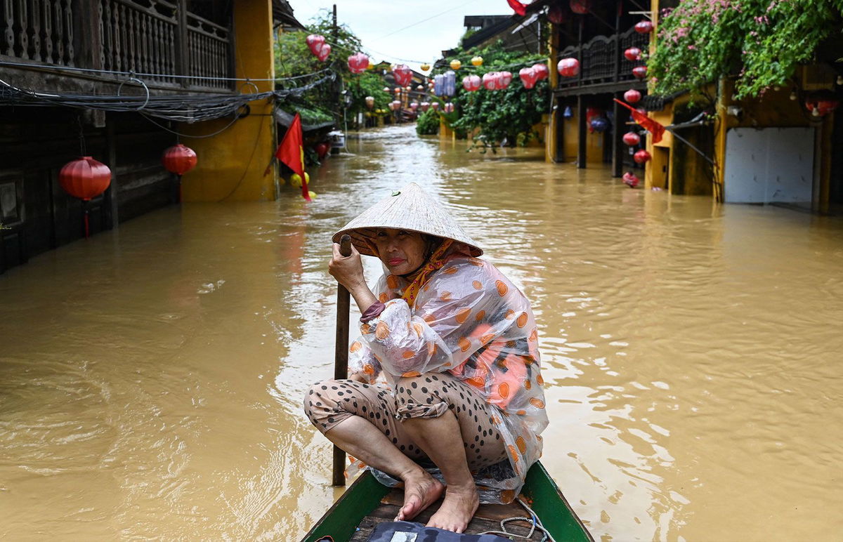 <i>Nhac Nguyen/AFP/Getty Images via CNN Newsource</i><br/>A woman rows a boat on a flooded street following heavy rains in Hoi An